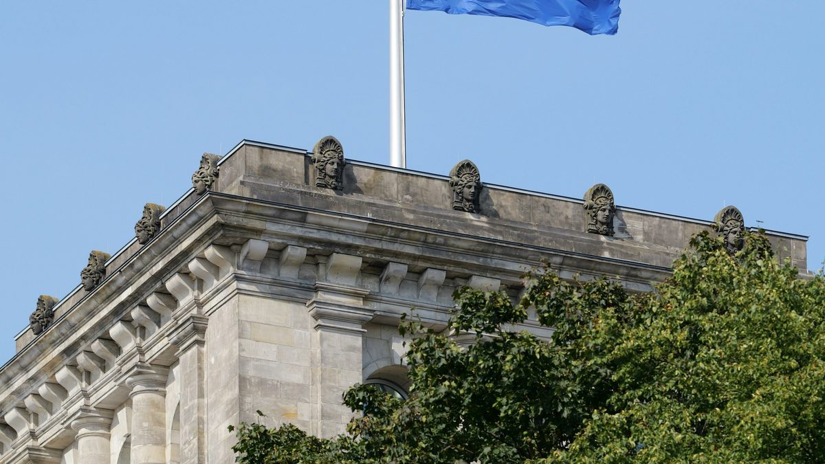 European Union flag flying above a stone government building