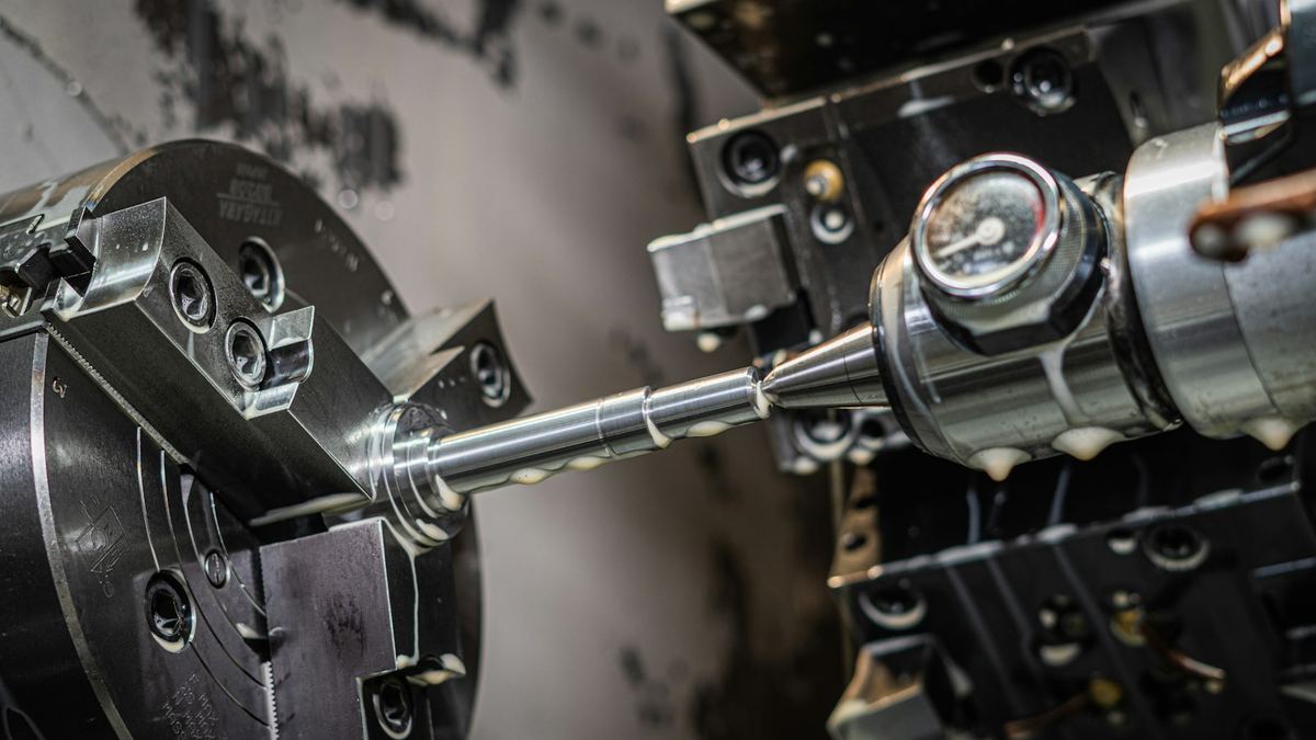 Close-up of a precision CNC lathe machining a metal shaft