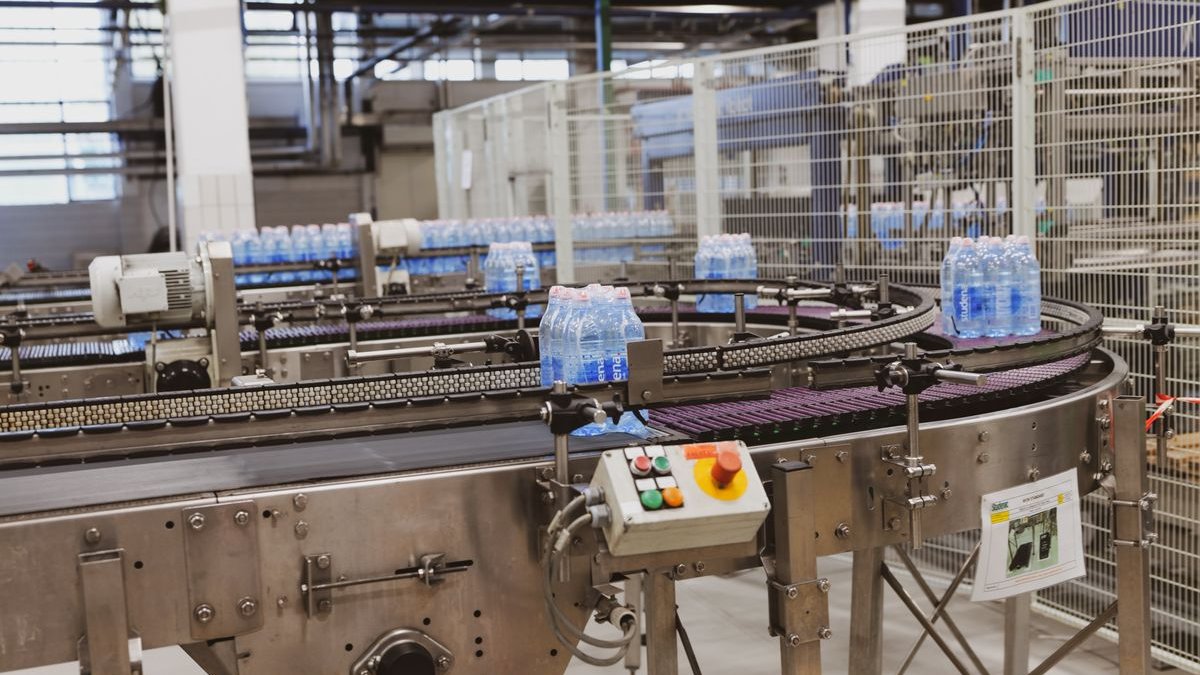 Automated bottling and packaging conveyor line inside an industrial facility