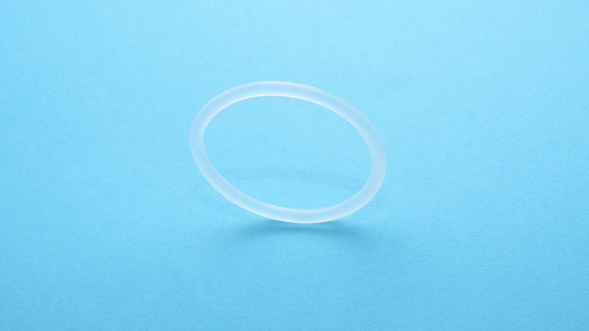 A translucent silicone O-ring on a plain blue background